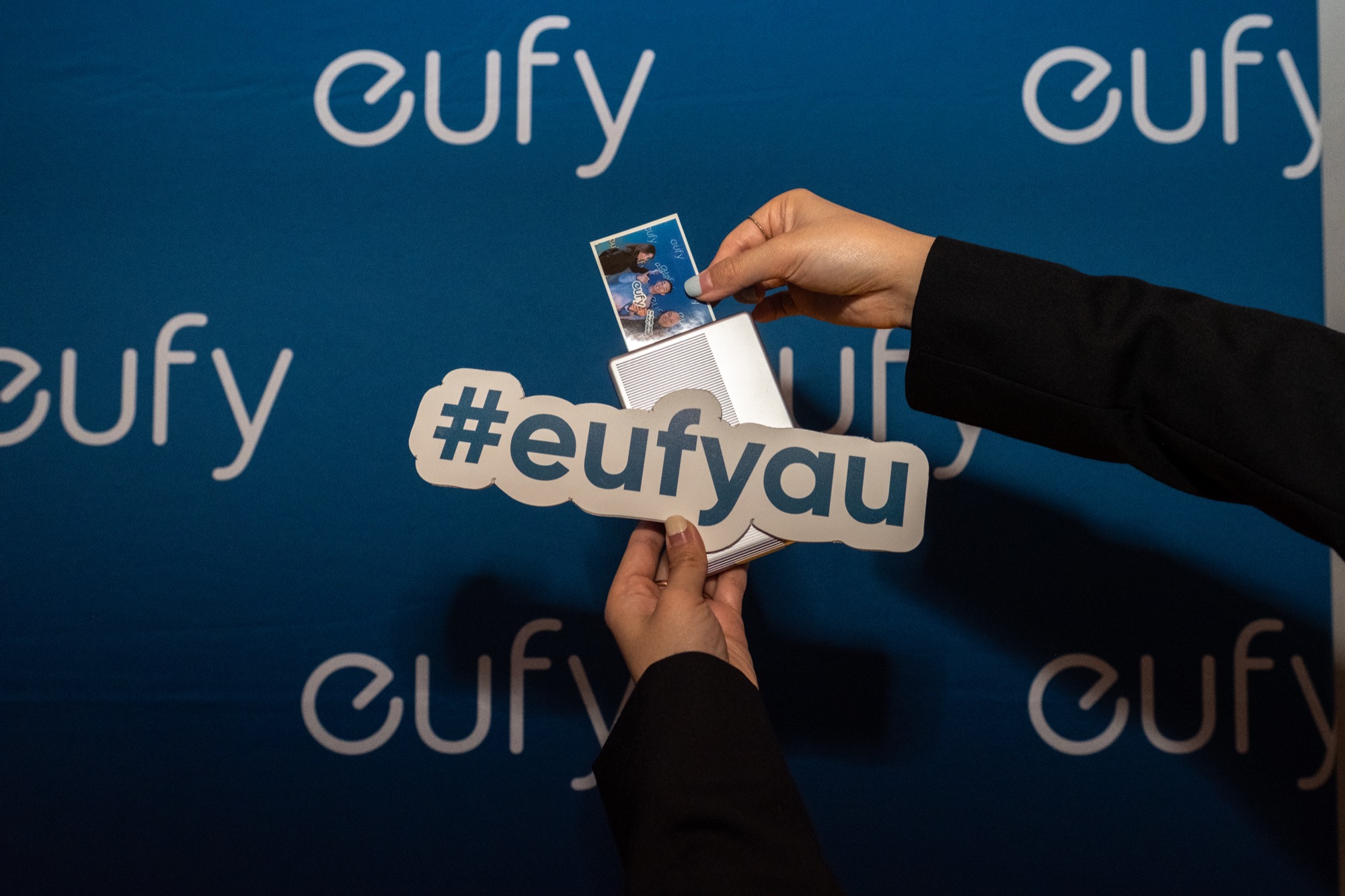 Guests holding an instant photo branded #eufyau