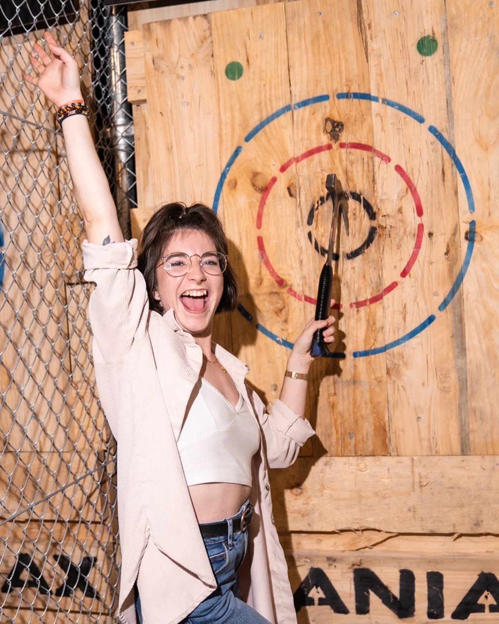 Guest celebrating a bullseye at Maniax Axe Throwing